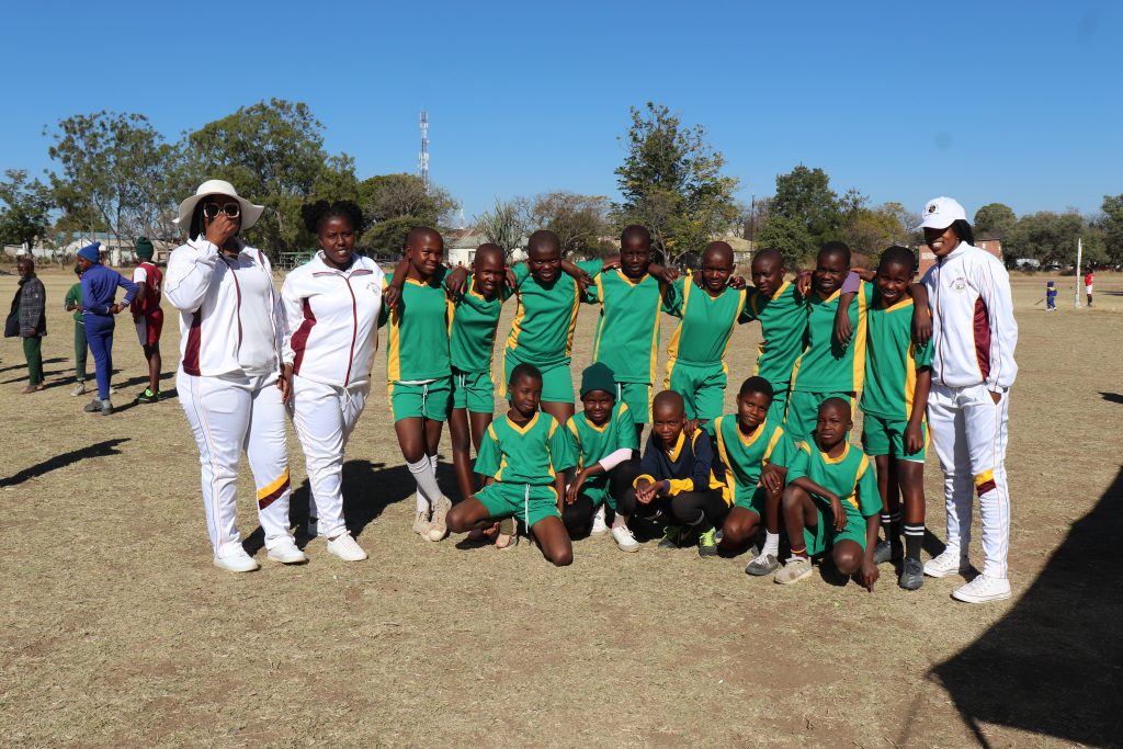 Primary school learners and coaches during ball games at Plumtree High School, celebrating teamwork and sportsmanship