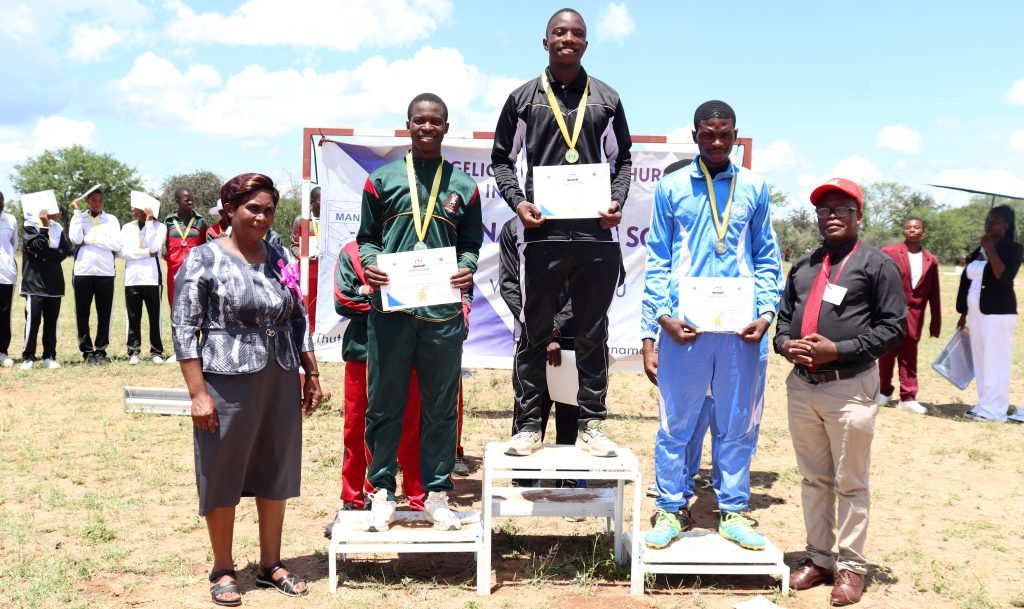 Provincial Education Director presenting awards to the Under-20 boys athletes during the graduation ceremony at the 2026 Matabeleland South Provincial Athletics held at Manama High School.